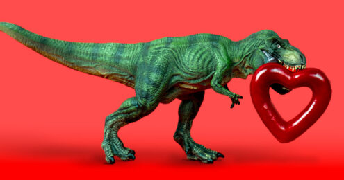 founder's syndrome - a green plastic T-rex walking across a red background with a shiny red heart that has a hollow center carried in its mouth