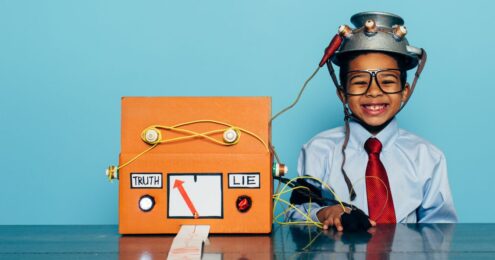 picture of a young child wearing glasses and a business shirt and tie with a helmet on attached to a lie detector with an arrow between the words Truth and Lie with the arrow pointing to lie.