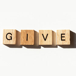 nonprofit board giving policy - G I V E spelled out on plain wooden blocks