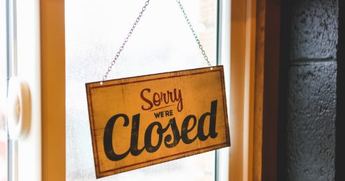 how to dissolve a nonprofit - a sorry we're closed sign hanging on a glass door