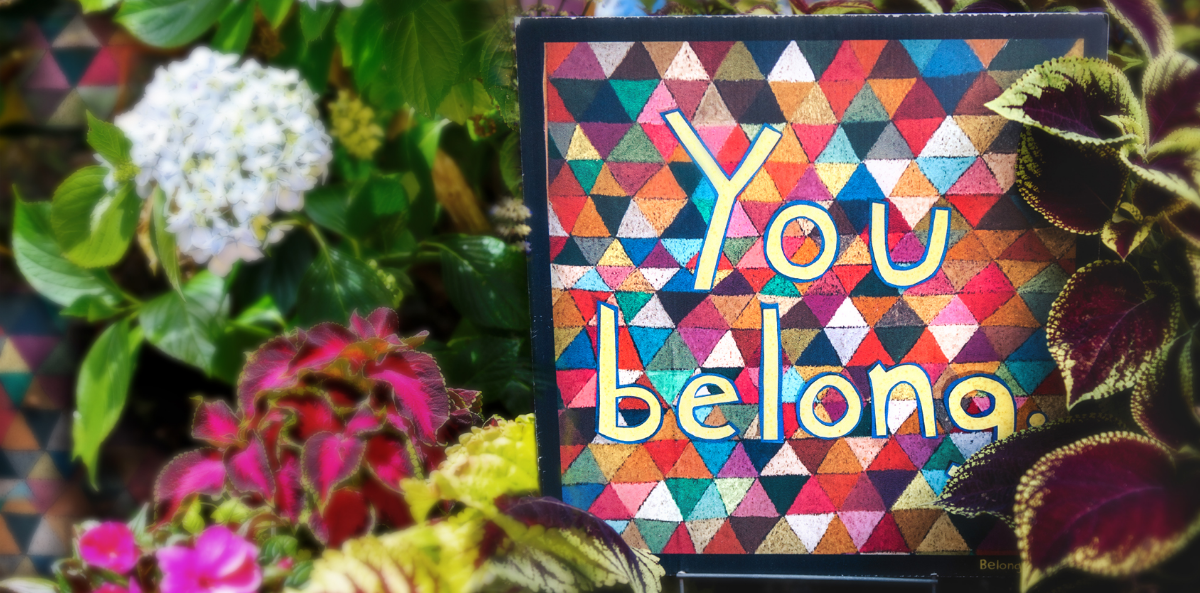a background with green, pink and yellow plants and flowers with a multicolored mosaic saying "You Belong". Represents chief diversity officers and DEI efforts.